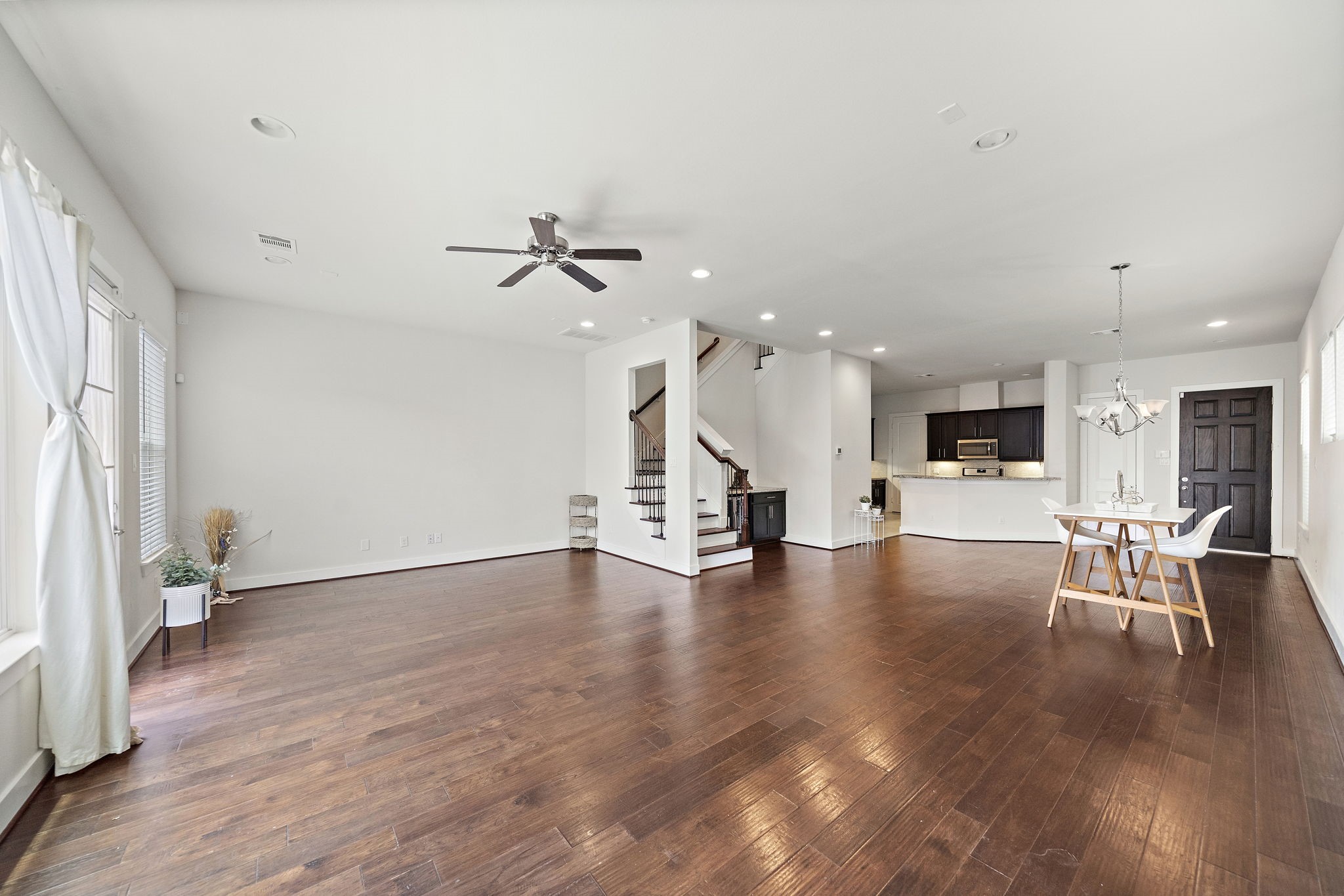9517 Cedarpost Square Street Houston, TX 77055 - Photo 6 of 20 a view of an empty room with wooden floor and a ceiling fan