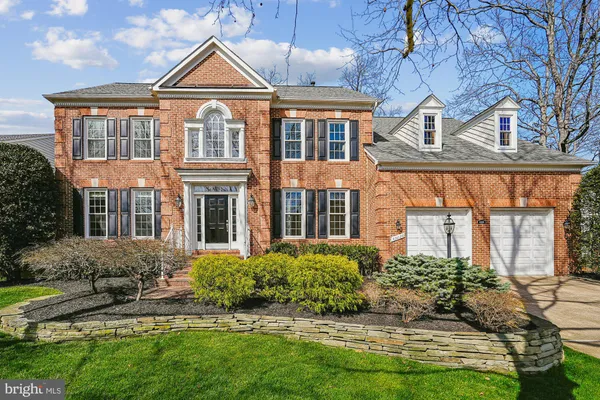 a view of a brick house with a yard patio and a fire pit