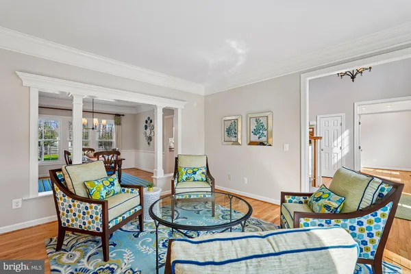 a dining room with furniture a chandelier and wooden floor