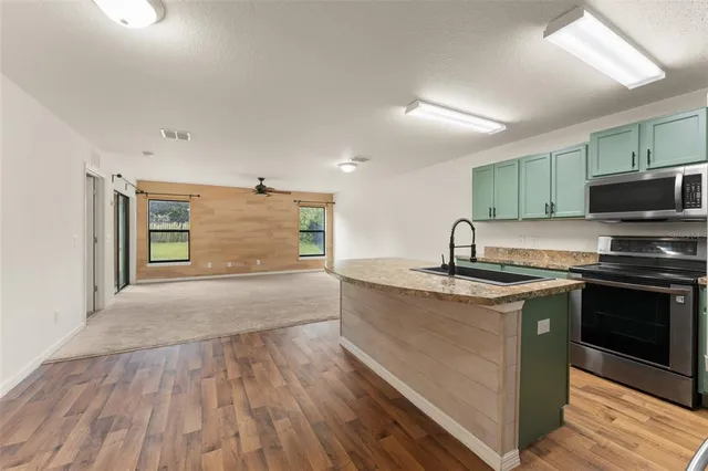 a kitchen with stainless steel appliances granite countertop a sink and a stove top oven