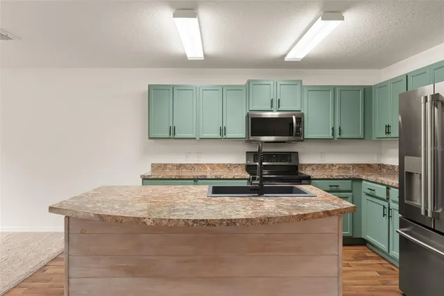 a kitchen with granite countertop a stove and a microwave