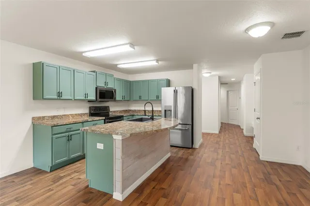a kitchen with stainless steel appliances a stove refrigerator sink and cabinets