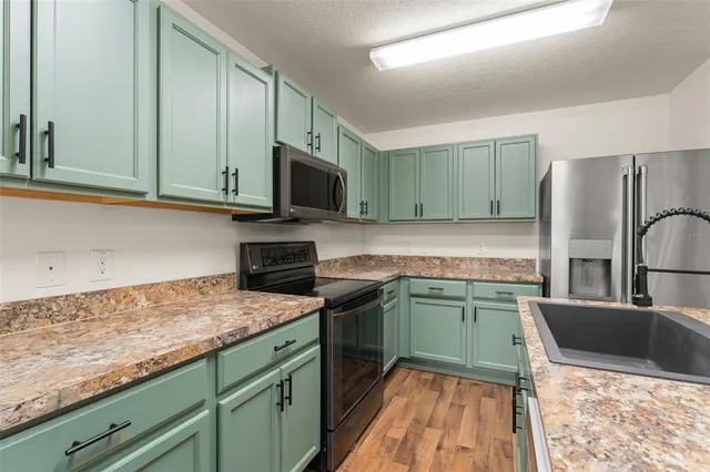 a kitchen with granite countertop a sink and steel appliances