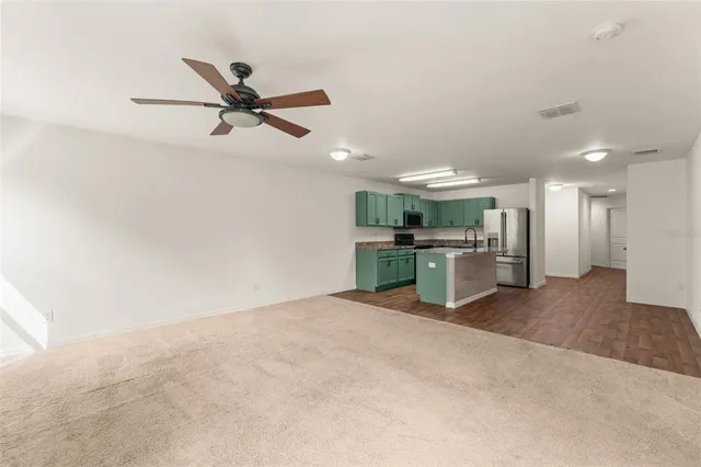 a view of a kitchen with a sink and a refrigerator