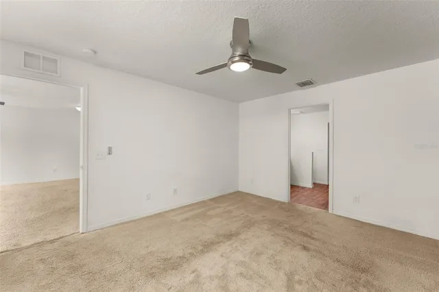 en empty room with ceiling fan and window
