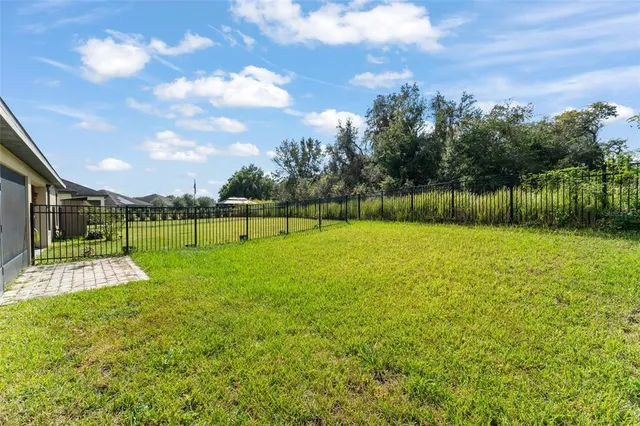 a front view of house with yard and trees in the background