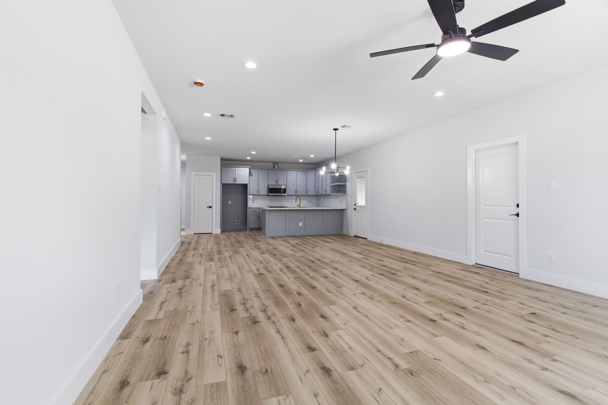 7040 Kinney Street Houston, TX 77087 - Photo 8 of 47 a big room with wooden floor and a kitchen view