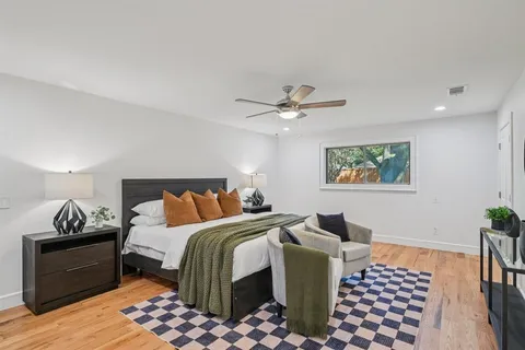 a bedroom with bed lamp and a rug