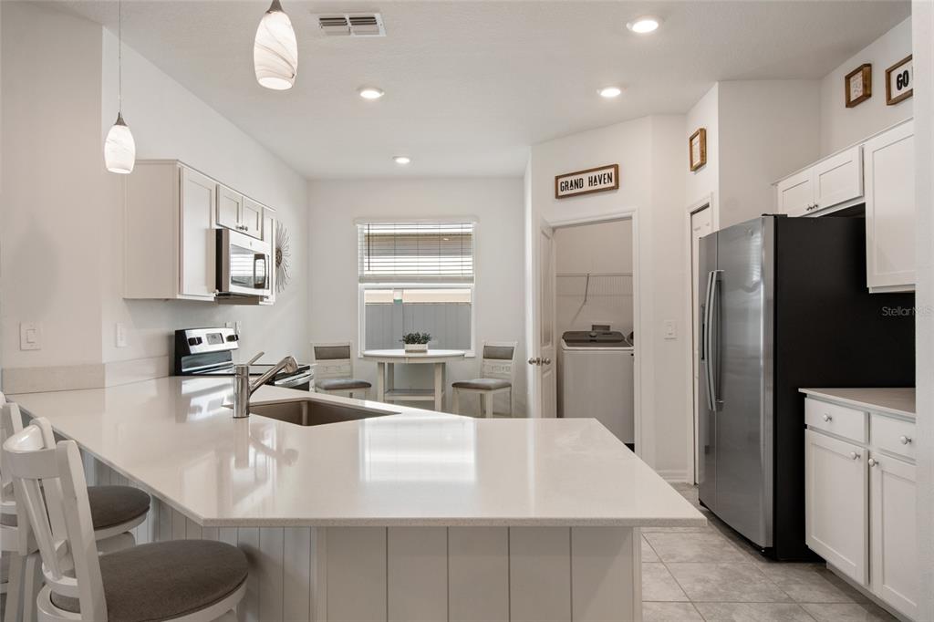 1172 Tyler Loop Lake Wales, FL 33859 - Photo 9 of 56 a kitchen with stainless steel appliances a sink a refrigerator a stove a microwave and dining table