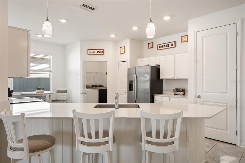 1172 Tyler Loop Lake Wales, FL 33859 - Photo 10 of 56 a kitchen with a dining table chairs and white cabinets