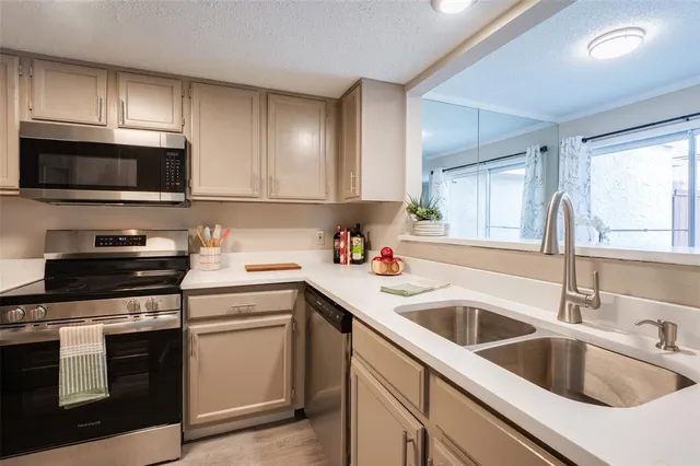 a kitchen with granite countertop white cabinets and stainless steel appliances