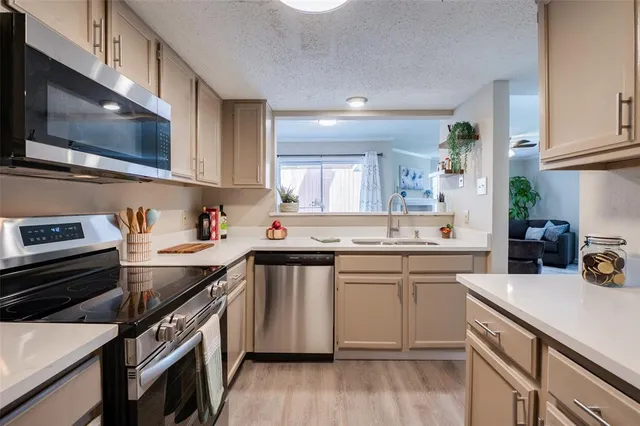 a kitchen with a sink a stove and cabinets