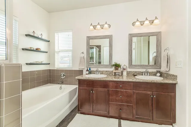 a bathroom with a tub sink and mirror