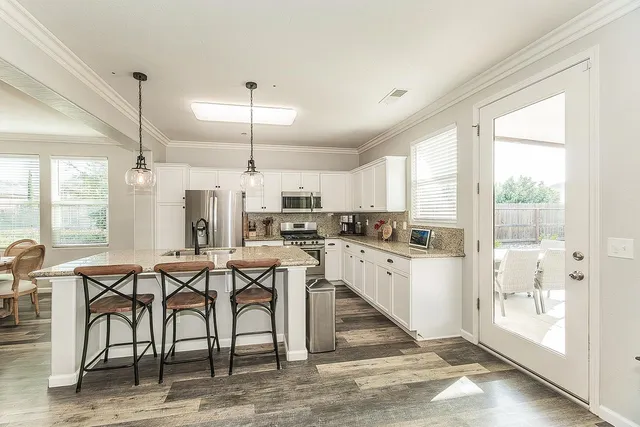 a kitchen with a table chairs refrigerator and cabinets