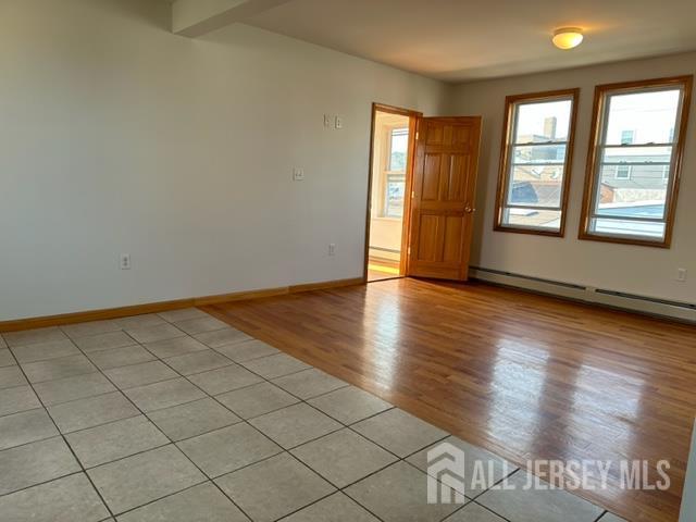 321 Pershing Avenue, Unit 2 Carteret, NJ 07008 - Photo 12 of 16 an empty room with wooden floor and windows