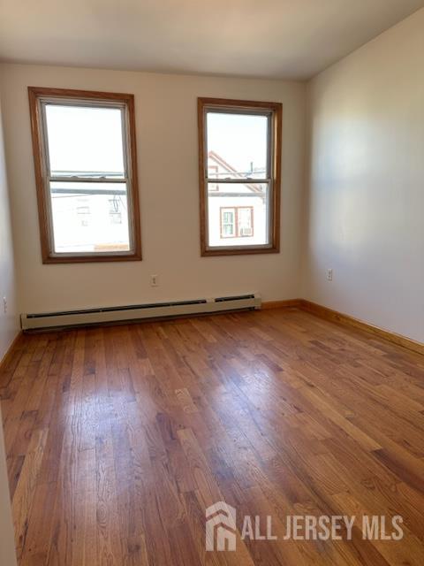 321 Pershing Avenue, Unit 2 Carteret, NJ 07008 - Photo 4 of 16 an empty room with wooden floor and windows