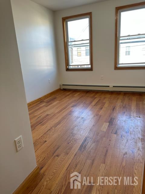 321 Pershing Avenue, Unit 2 Carteret, NJ 07008 - Photo 5 of 16 an empty room with wooden floor and windows