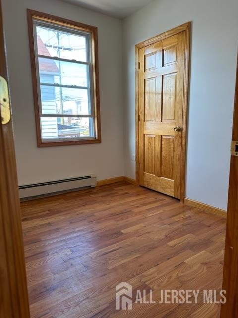 321 Pershing Avenue, Unit 2 Carteret, NJ 07008 - Photo 8 of 16 an empty room with wooden floor and windows