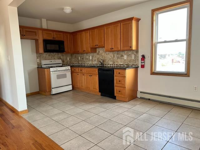 321 Pershing Avenue, Unit 2 Carteret, NJ 07008 - Photo 9 of 16 a kitchen with stainless steel appliances granite countertop a stove a sink and a microwave