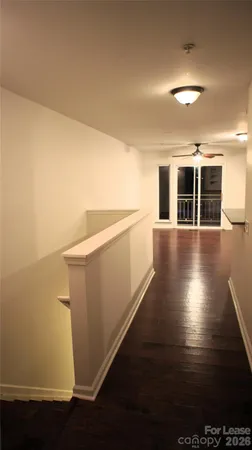 a view of a kitchen with wooden floor and white walls