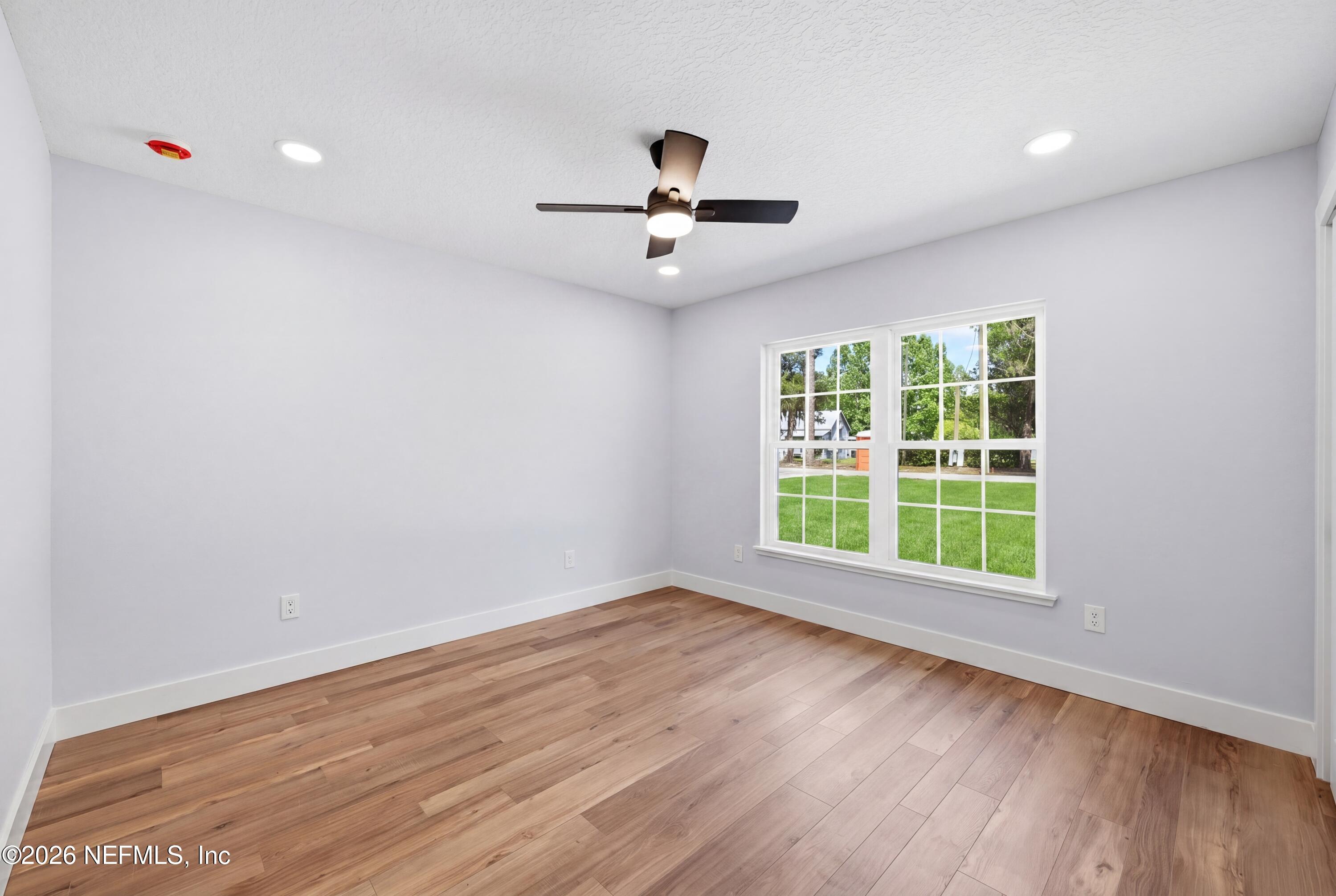 287 Peniel Church Road Palatka, FL 32177 - Photo 12 of 21 an empty room with wooden floor ceiling fan and windows
