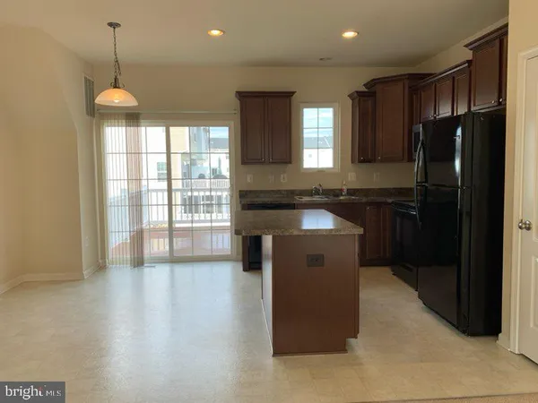 a kitchen with stainless steel appliances granite countertop a refrigerator a sink a stove and a refrigerator