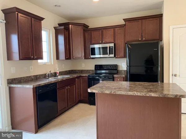 a kitchen with stainless steel appliances granite countertop a stove microwave and refrigerator