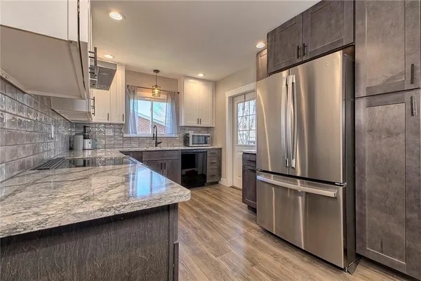 a kitchen with granite countertop a sink dishwasher and cabinets