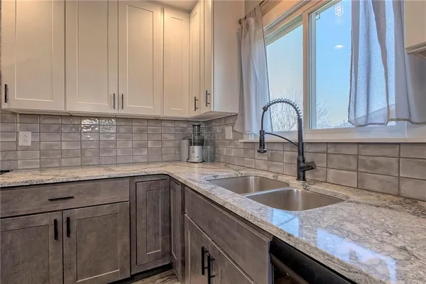a kitchen with granite countertop cabinets stainless steel appliances and a sink