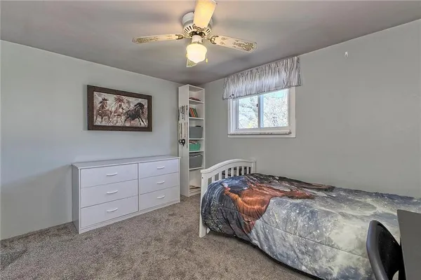 a bedroom with a bed and a table chair