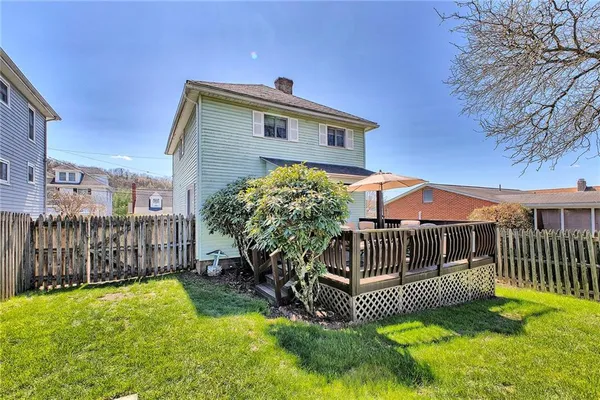 a view of a roof deck with table and chairs under an umbrella with wooden floor