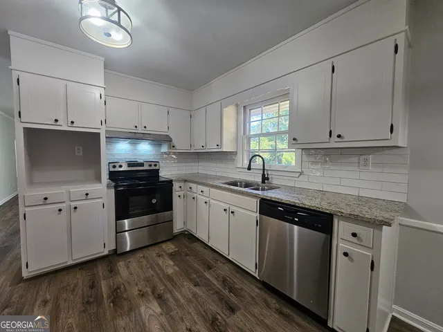 a kitchen with granite countertop cabinets stainless steel appliances and a window