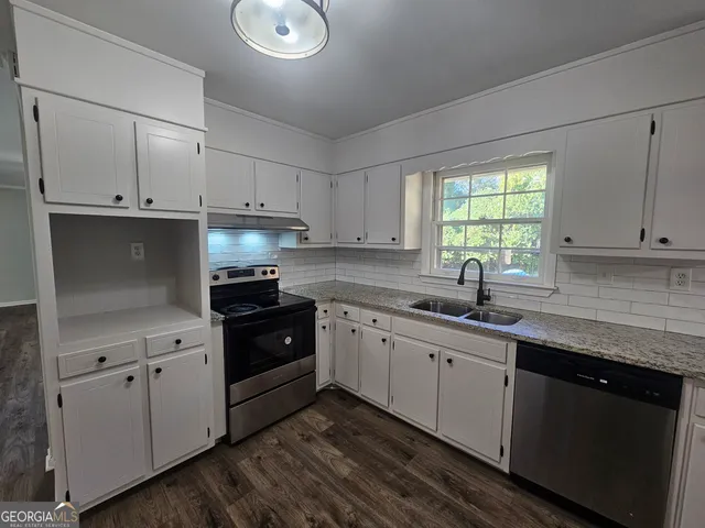 a kitchen with a sink stove and cabinets