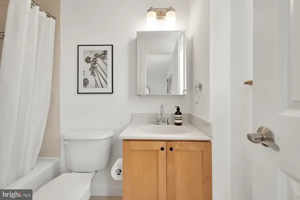 a bathroom with a granite countertop toilet sink and mirror