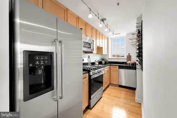 a kitchen with stainless steel appliances granite countertop a refrigerator and a stove