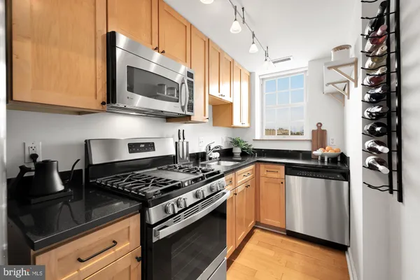 a kitchen with stainless steel appliances granite countertop a stove and a microwave