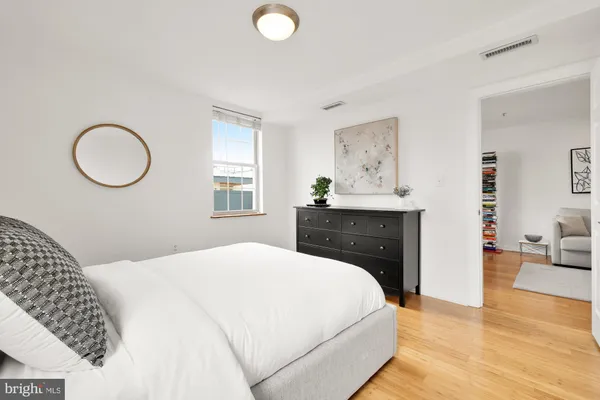 a bedroom with a bed and wooden floor