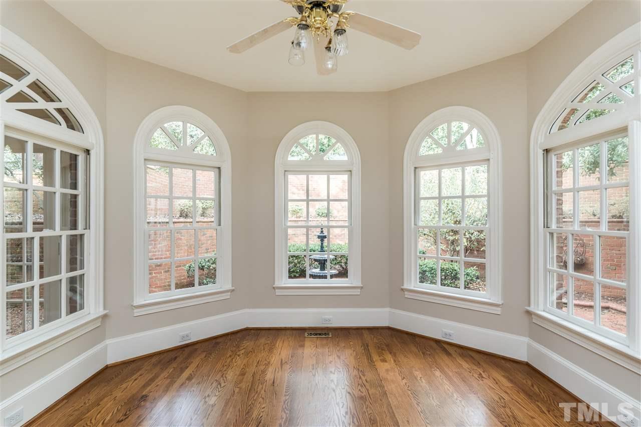3103 Landor Road Raleigh, NC 27609 - Photo 12 of 25 an empty room with wooden floor chandelier and windows