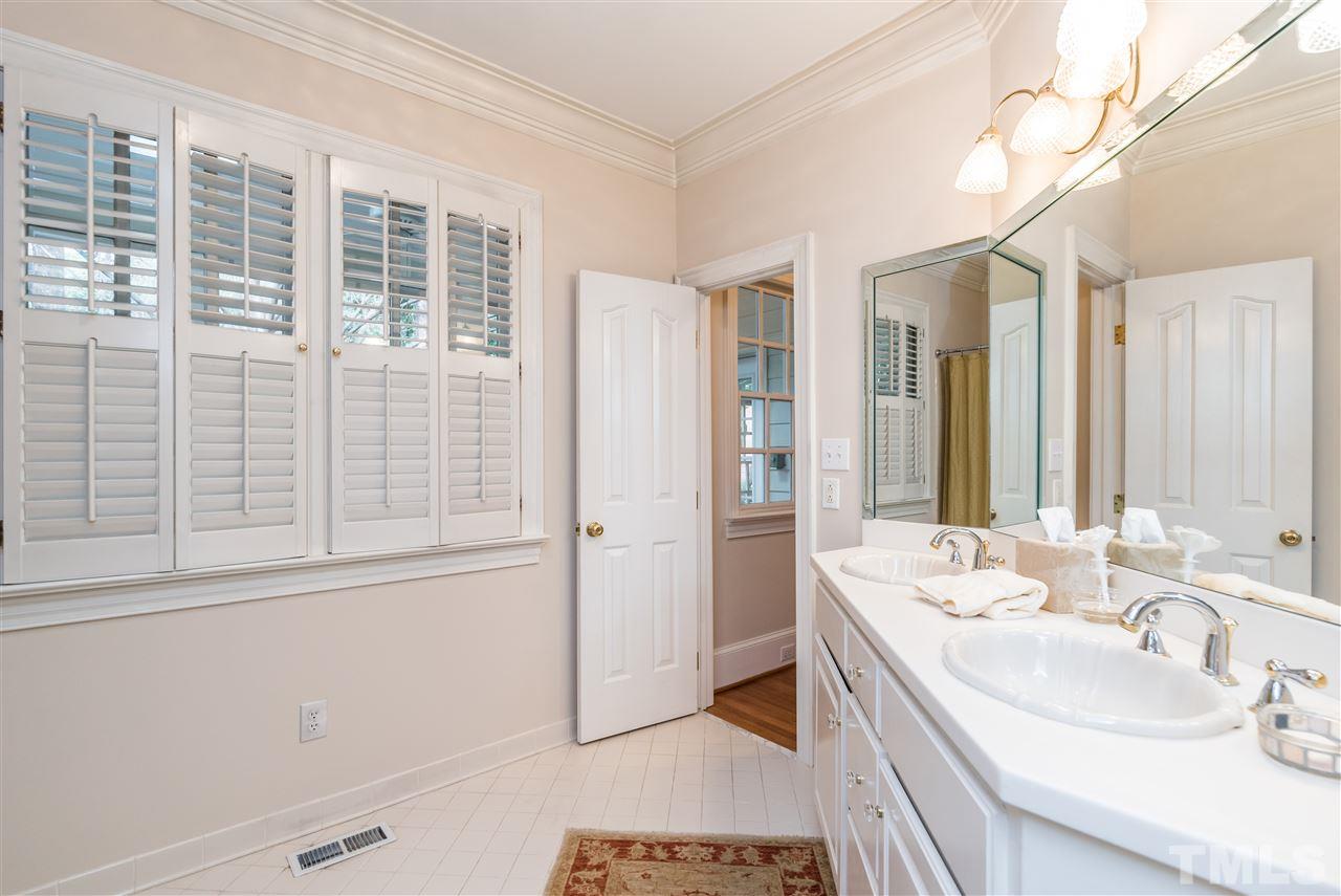 3103 Landor Road Raleigh, NC 27609 - Photo 14 of 25 a bathroom with a double vanity sink a mirror and a shower