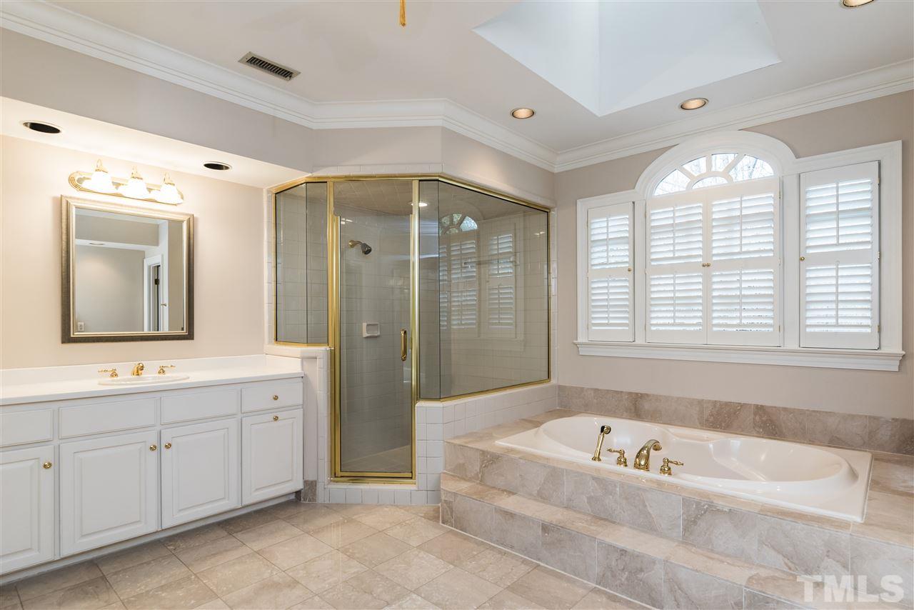 3103 Landor Road Raleigh, NC 27609 - Photo 18 of 25 a spacious bathroom with a tub a double vanity sink a window a shower and a mirror