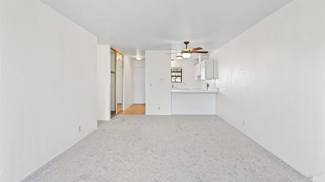 an empty room with kitchen view and a sink