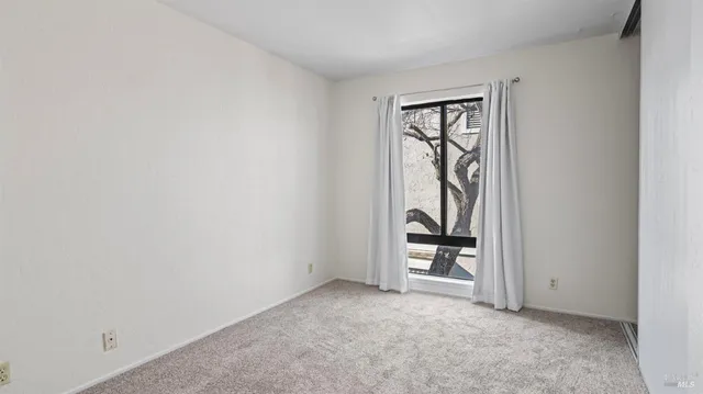 an empty room with windows and closet