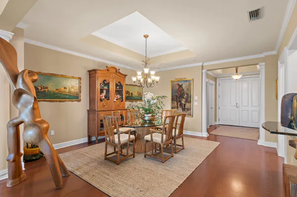 a dining room with furniture a chandelier and wooden floor