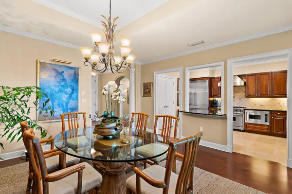 a kitchen with stainless steel appliances wooden floor and large windows