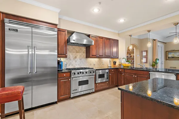 a kitchen with stainless steel appliances granite countertop a refrigerator and wooden cabinets