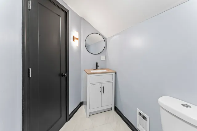 a bathroom with a sink a toilet and a mirror