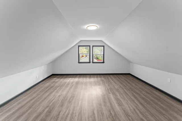 a view of a big room with wooden floor and a window