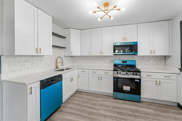 a kitchen with stainless steel appliances granite countertop a stove and a white cabinets
