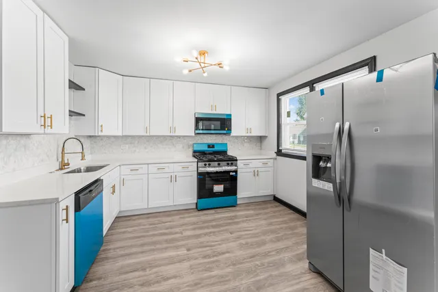 a kitchen with granite countertop a refrigerator stove and sink