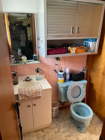 a bathroom with a granite countertop toilet sink and mirror